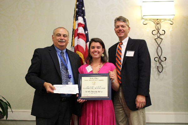 In July, Caroline Stalvey, a rising senior at Clemson University, receives her $5,000 science, technology, engineering and mathematics scholarship Tony Orlando (l), chapter president, while her father John looks on.